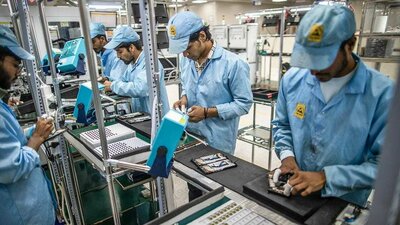 Image showing multiple individuals in a manufacturing unit assembling electronic devices on a production line