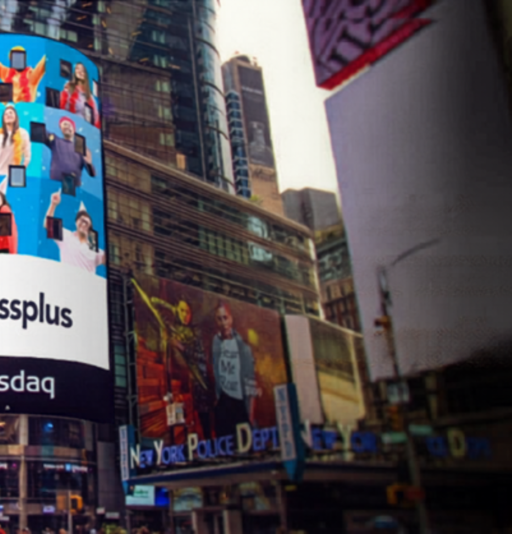 Slide showing a large digital billboard in Times Square displaying a company advertisement with multiple people images and branding, highlighting a hiring announcement and company presence on a prominent public display